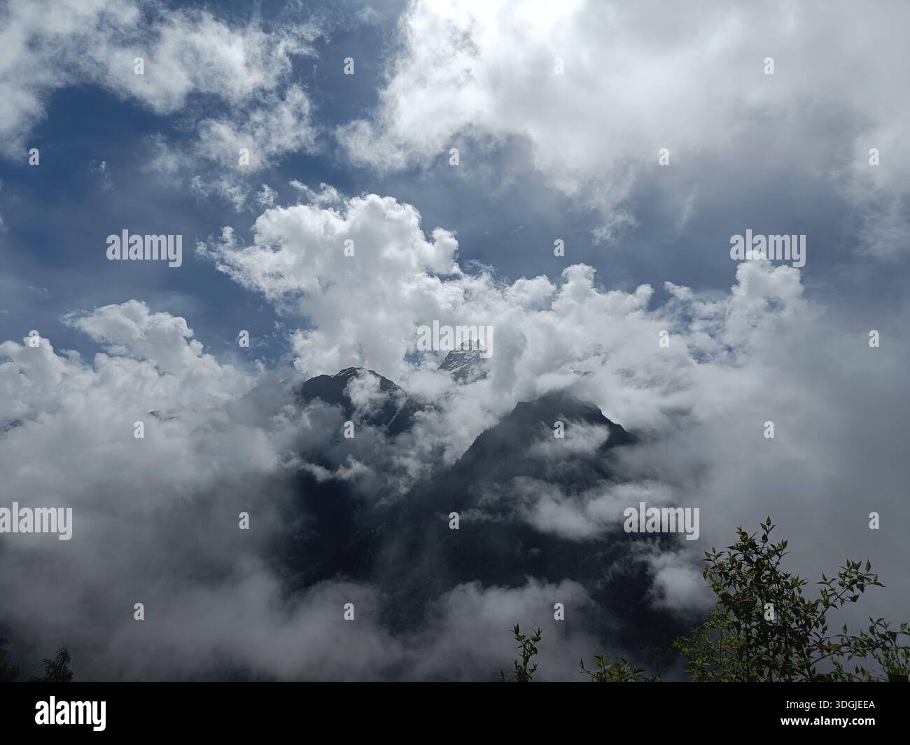 Niedrige Wolken umgeben eine Berglandschaft, Nebel und dramatische Wetterbedingungen. - Smartphone-aufgenommenes Stockfoto