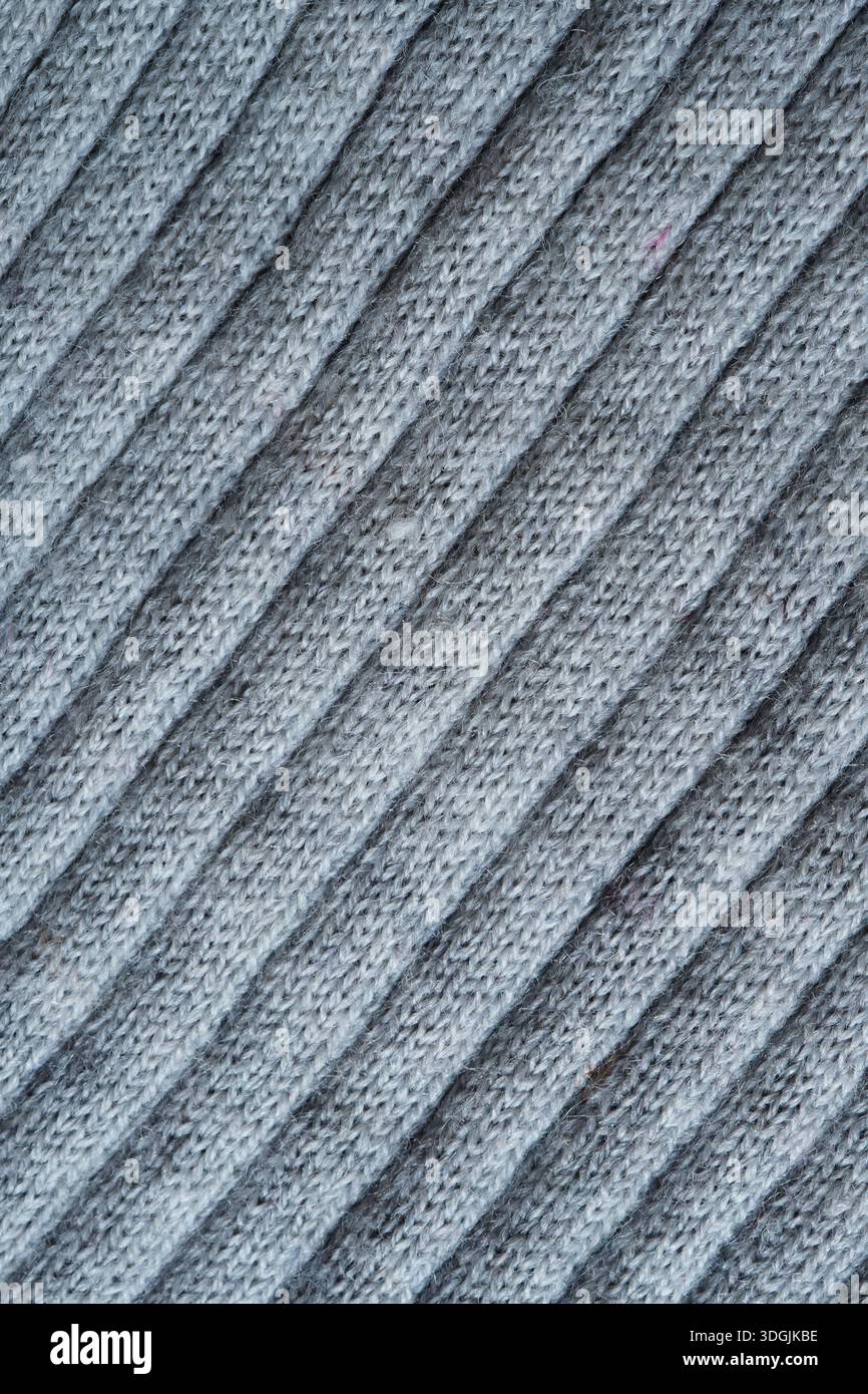 Großaufnahme von industriell gestricktem Polyester- und Wollmischgewebe von hellgrauem Hintergrund Stockfoto