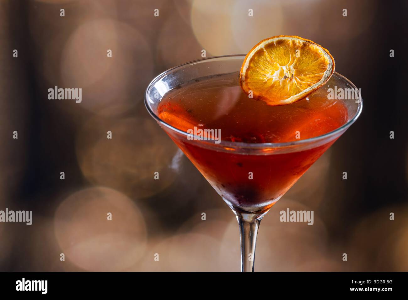 Whiskey-Cocktail oder manhattan serviert mit einer dehydrierten Orangenscheibe. Stockfoto