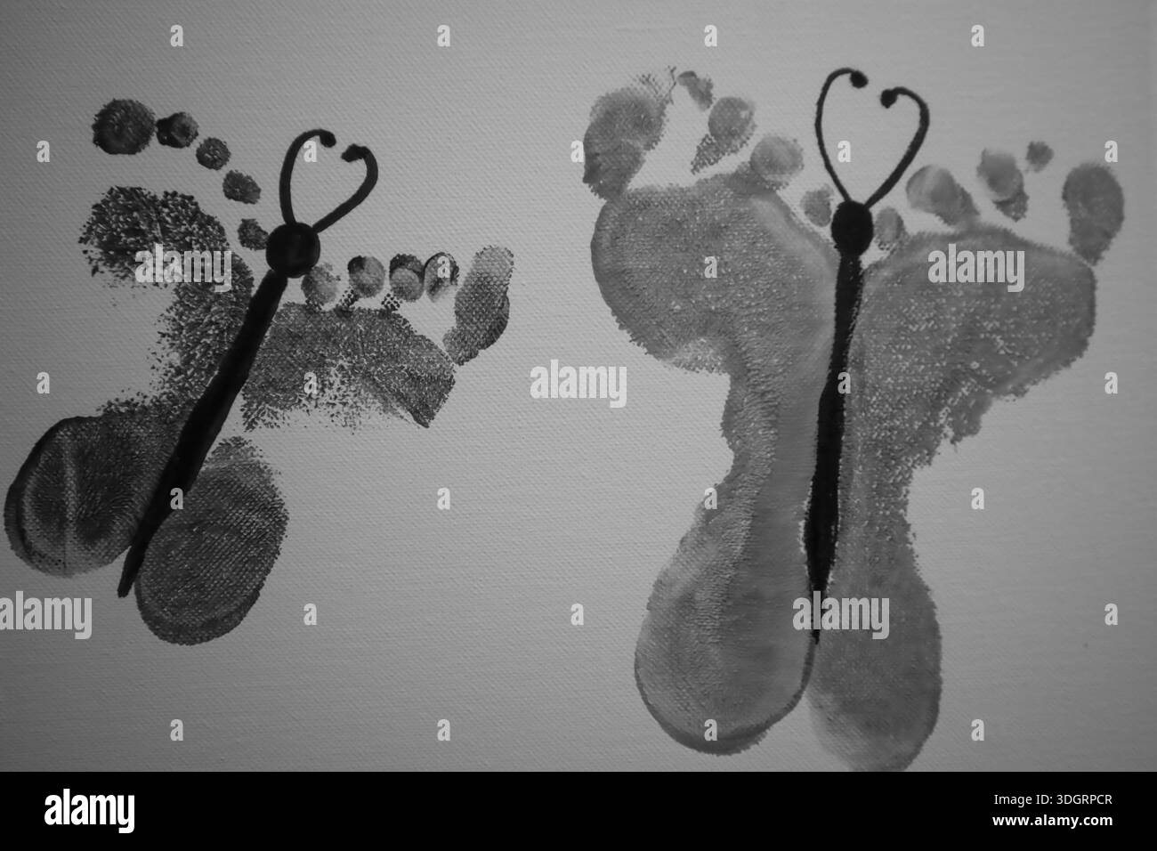Wunderschöne Schmetterlingsdesigns entstehen aus Hand- und Fußabdrücken und symbolisieren Unschuld und Kreativität. Die monochromatischen Farbtöne verleihen dem einen einzigartigen Touch Stockfoto