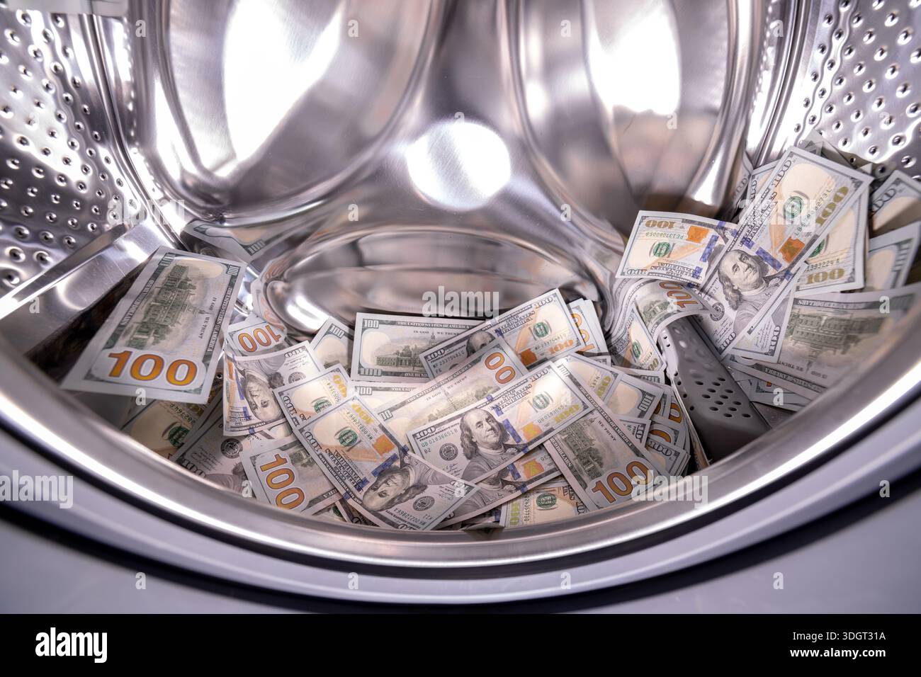 Hundert US-Dollar-Banknoten in der Waschmaschine für Geldwäsche und Betrug. Stockfoto