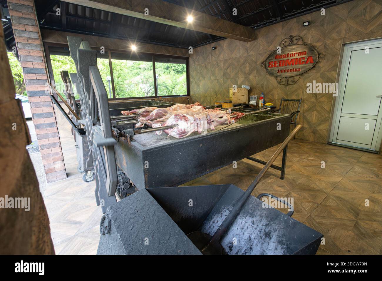 BUGOJNO, BIH, 05.23.2025: Geröstetes Lammfleisch auf einem Stahlspieß und auf einem Holzkohlegrill. Stockfoto