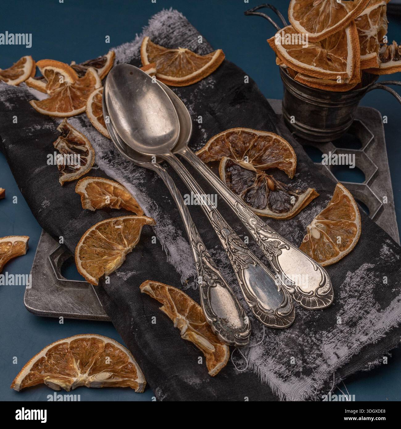 Vintage Küchenbesteck Gabeln auf dunklem rustikalem Hintergrund mit verschiedenen trockenen Orangen, Blick von oben. Besteckset in antikem Silber, kunstvolles Design. Stockfoto