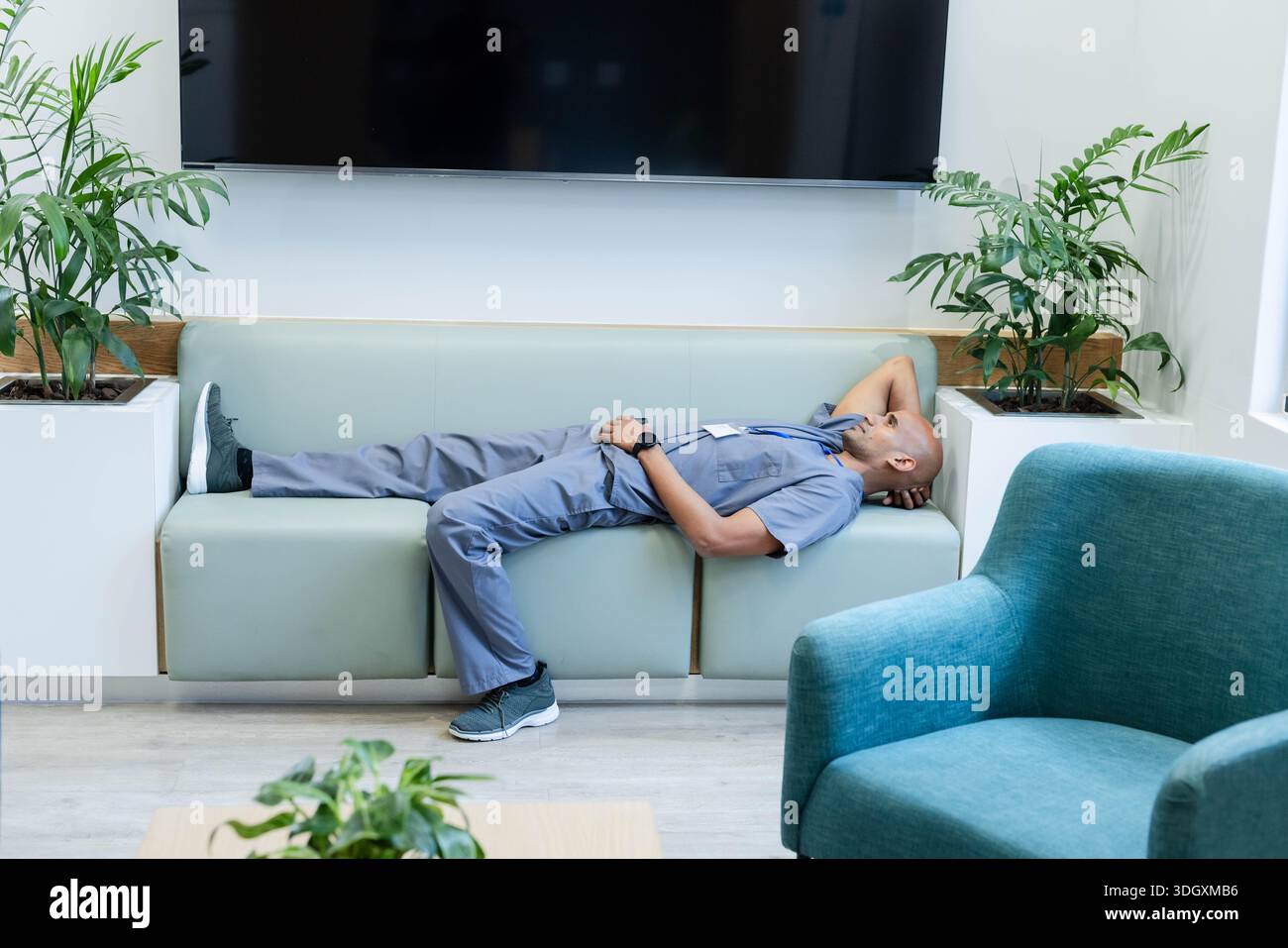 Hellblaue Peelings liegen auf der mintgrünen Bank in der Klinik-Lounge, mit Ausweis-ID-Abzeichen Stockfoto