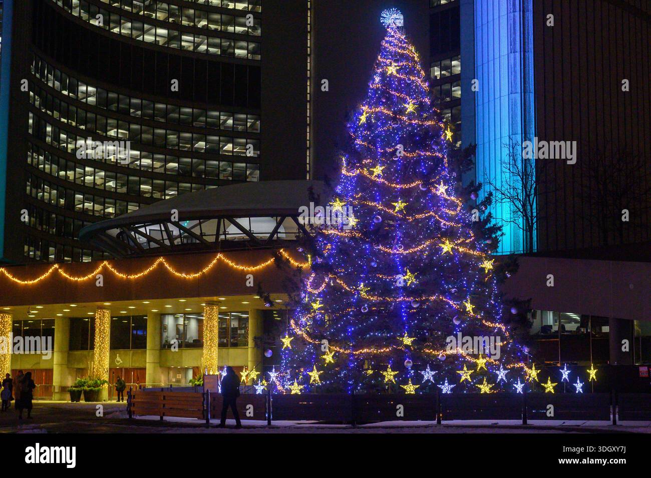 Toronto, ON, Kanada 20. Dezember 2025, großer Weihnachtsbaum, hell beleuchtet mit blauen und goldenen Lichtern am Nathan Phillips Square während Toronto Cavalcad Stockfoto