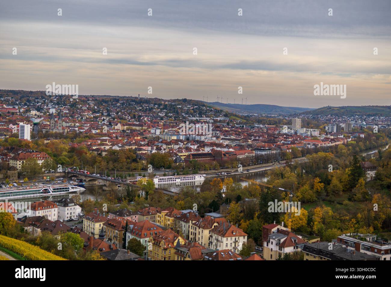 Weites Hochpanorama von Würzburg mit dem Main mit Brücken und Passagierkreuzschiffen umgeben von dichtem Stadtbau. Stockfoto