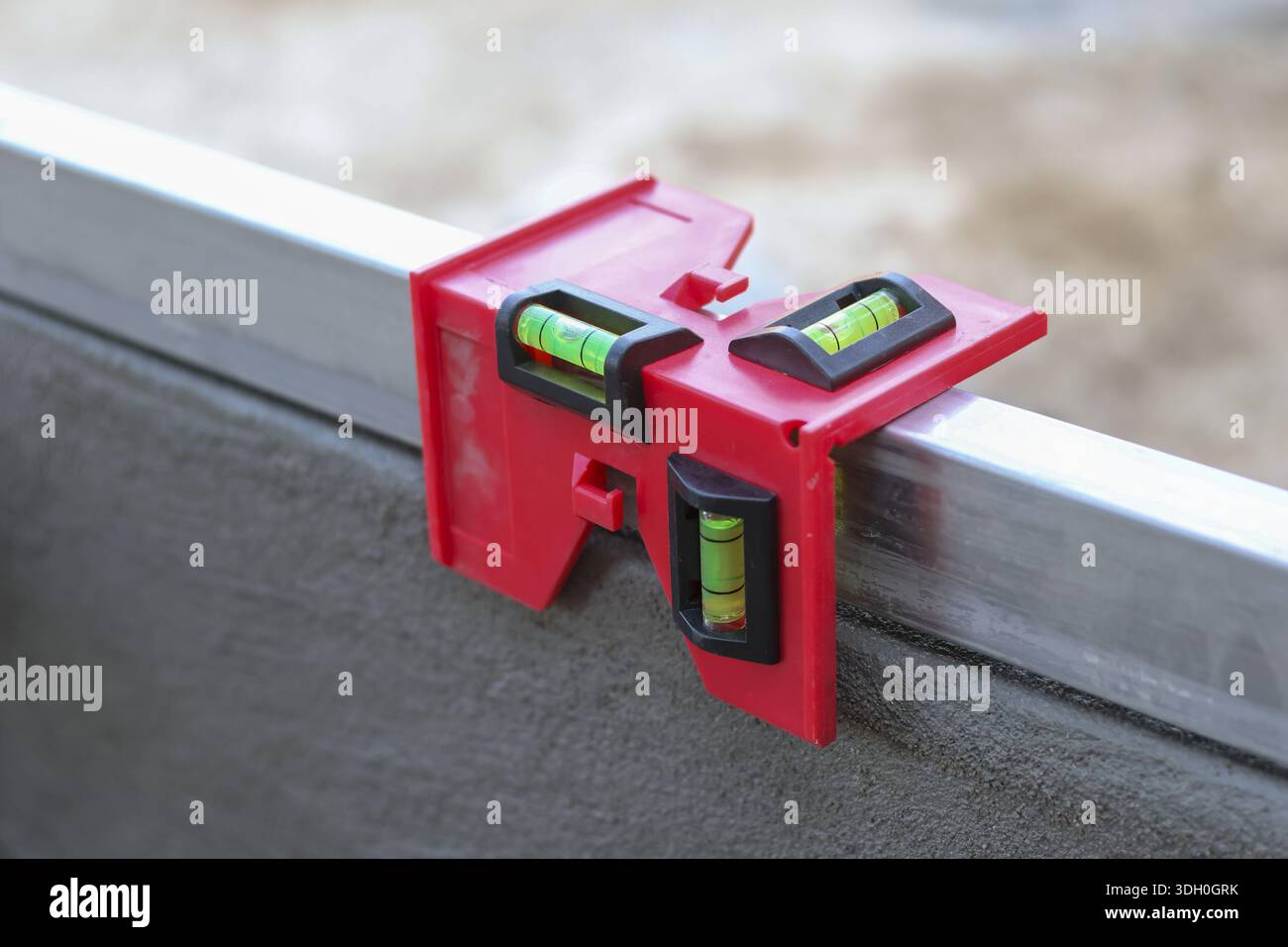 Rote Kunststoffpfosten, die auf Metallbalken geklemmt sind, gewährleisten eine genaue Struktur und vertikale Ausrichtung der Baustelle, die zuverlässig und fokussiert ist Stockfoto