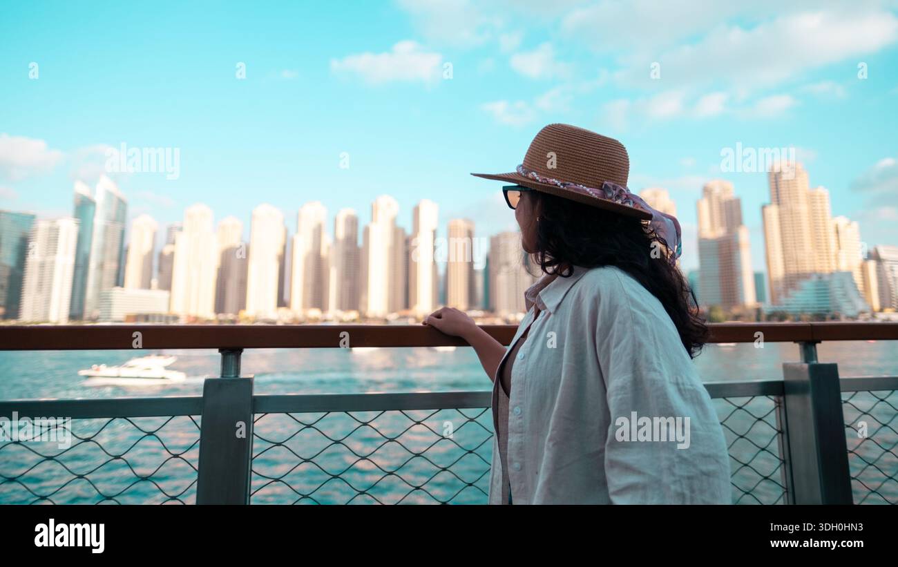 Frau am Wasser mit Blick auf die Skyline von Bluewater Island Dubai, Dubai Ain, JBR Beach Walk, Dubai Marina Stockfoto