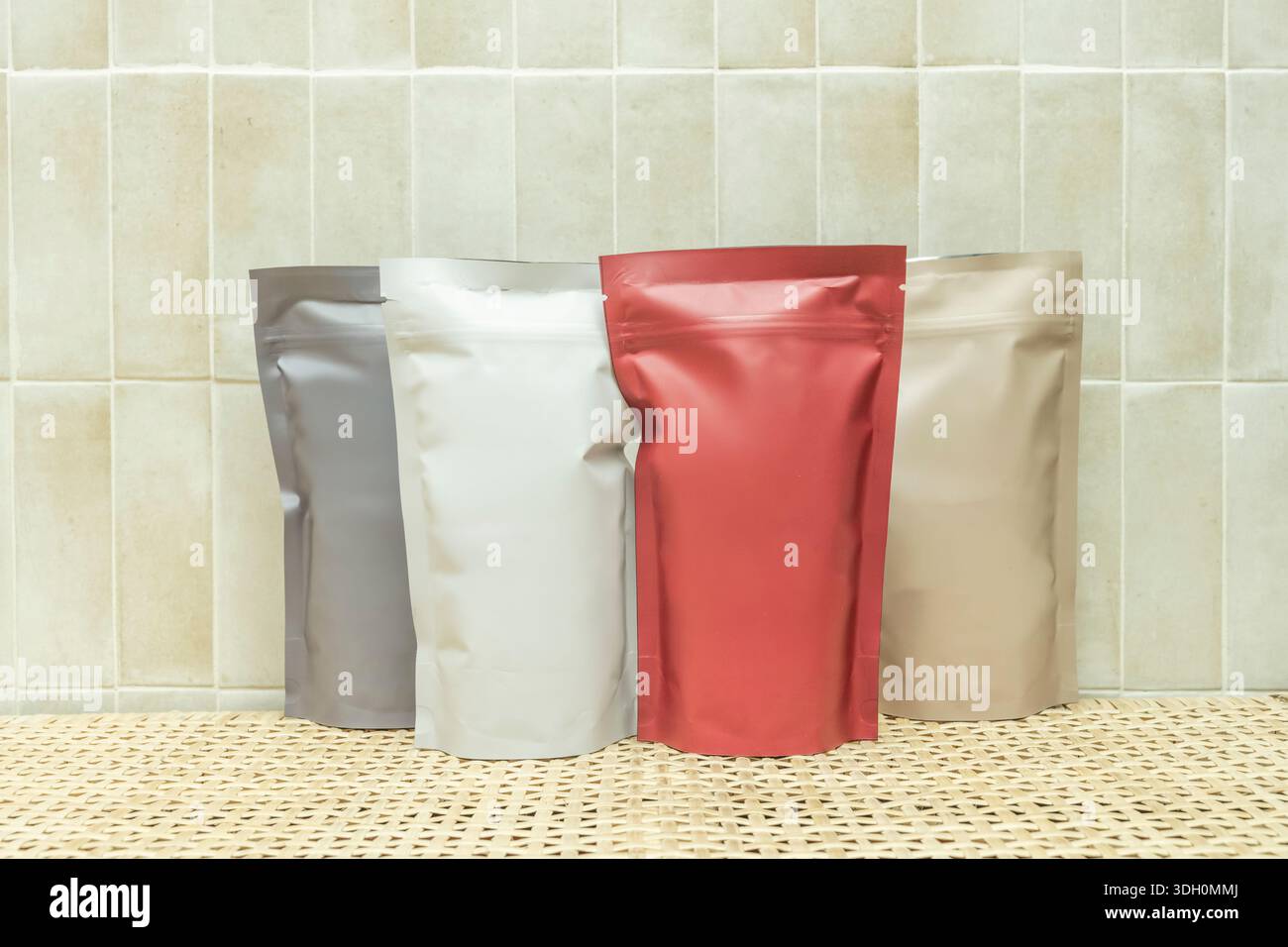 Kaffeebeutel in verschiedenen Farben auf einer Korbmatte Stockfoto