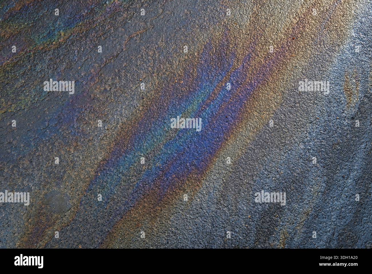 Farbenfrohe Ölleckenmuster auf Asphalt Stockfoto