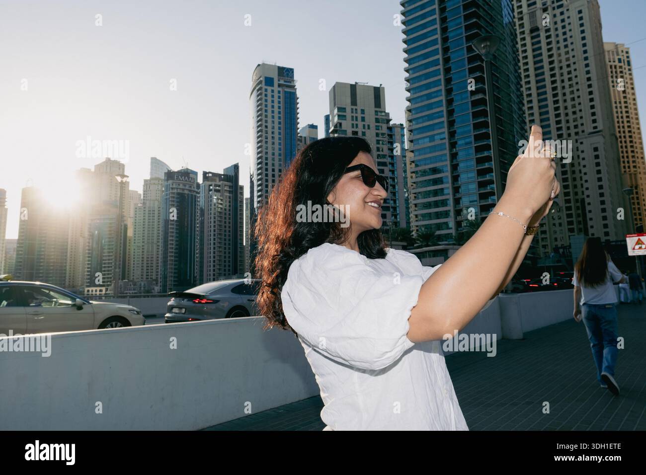 Frau, die Fotos mit ihrem Handy in Dubai macht, Reiseziele und Bucket List 2026 Stockfoto
