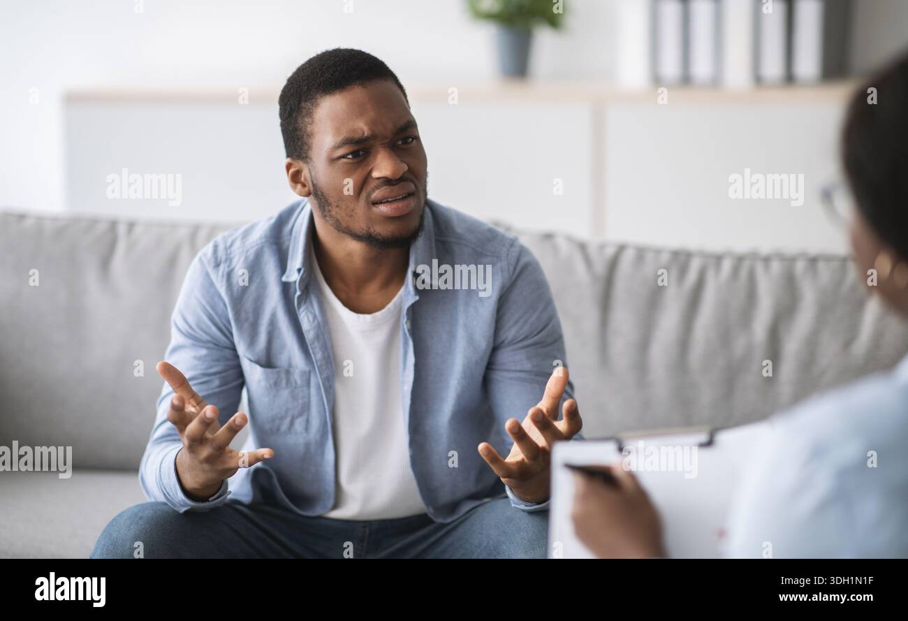 Psychologe hilft depressiven jungen schwarzen Mann, Beratung zu männlichen Patienten im Büro Stockfoto