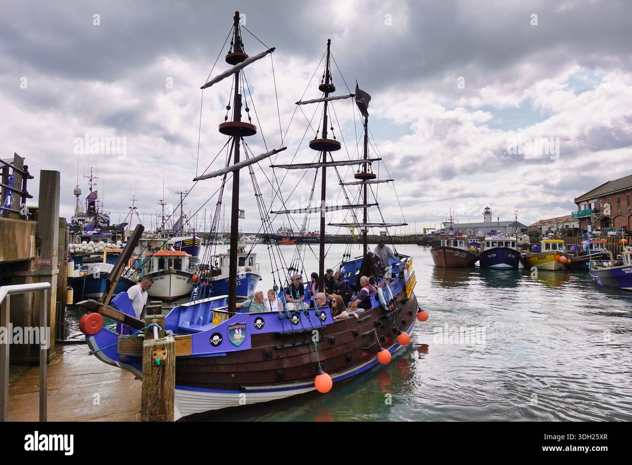 Das Piratenschiff Hispaniola im Hafen von Scarborough ist bereit, eine Schiffsladung von Menschen auf eine Bootsfahrt durch South Bay - North Yorkshire, England, Großbritannien zu nehmen Stockfoto