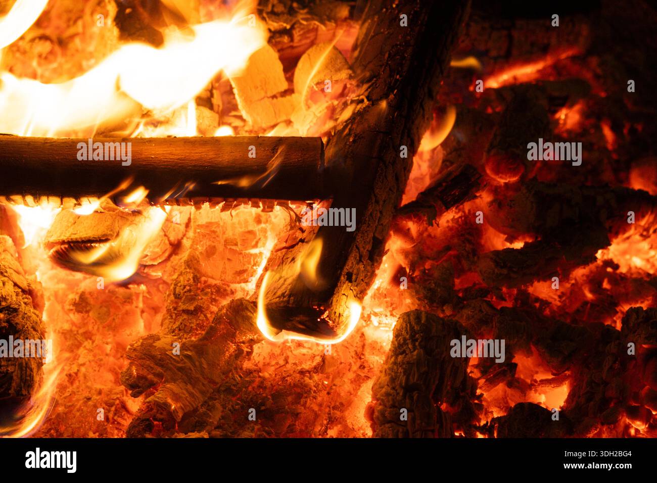Nahaufnahme von brennenden Logs mit intensiven gelben und orangefarbenen Flammen Stockfoto