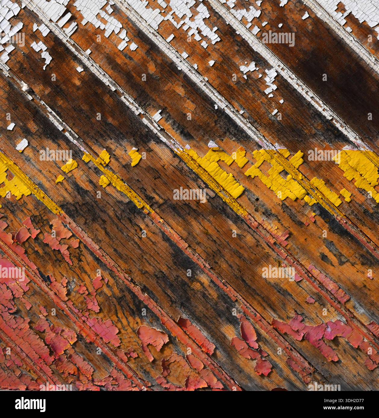 Das Hintergrundbild hat eine diagonale Nut in den Rillenbrettern und eine abgebrochene weiße, gelbe und rote Farbe. Stockfoto