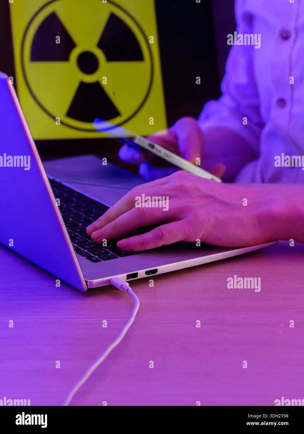 Nahansicht der Tippaktion auf tragbaren Geräten mit Warnemblem, die Sicherheitsprobleme hervorhebt. Stockfoto