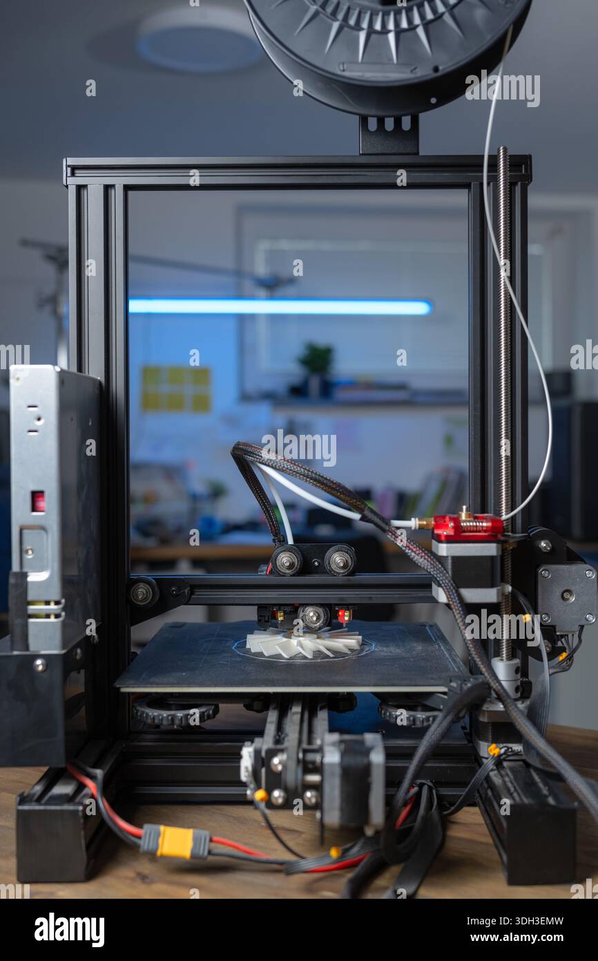 Ein 3D-Drucker produziert einen Prototyp aus Kunststoff in einem sauberen Arbeitsbereich mit additiver Fertigung. Stockfoto