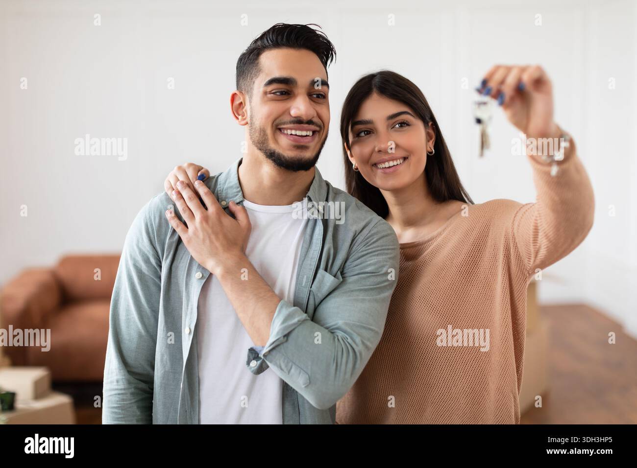 Glückliches Paar, das die Schlüssel ihrer Wohnung zeigte Stockfoto