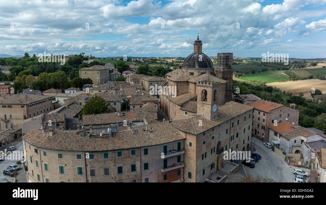 Die Drohnenfotografie zeigt eine historische italienische Stadt mit einer prominenten Kathedrale, umgeben von üppigen Landschaften und traditioneller Architektur Stockfoto