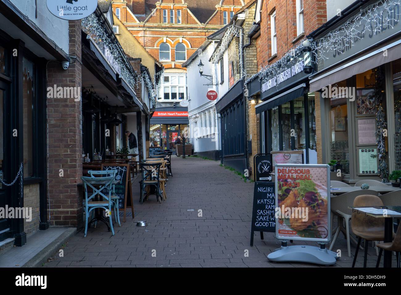 Eine enge Straße in Saffron Walden, gesäumt von Geschäften und Restaurants, dekoriert mit funkelnden Lichtern zu Weihnachten Stockfoto