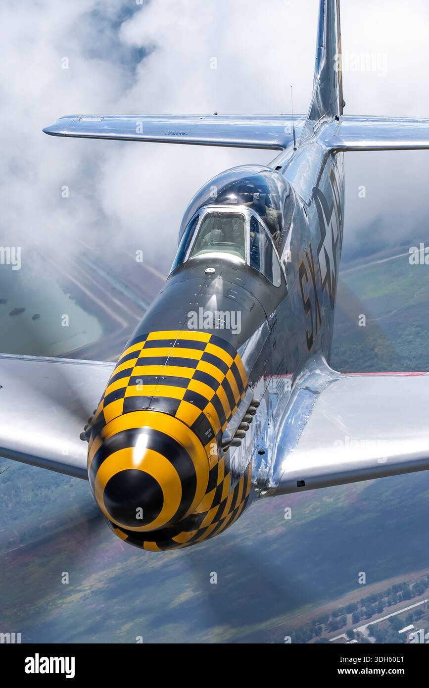 Luft-Luft-Ansicht des nordamerikanischen P-51D Mustang Kampfflugzeugs Double Trouble Two. Das Flugzeug mit der Registrierung N51EA trägt die Kennzeichen der United States Air Force und den Militärcode SX-B. Sie ist mit einem Packard Rolls Royce Merlin V-1650-Kolbenmotor ausgestattet, ein charakteristisches Merkmal dieses Flugzeugtyps. Das Foto zeigt das Flugzeug im Flug über Florida während der Teilnahme an der Sun N Fun Aerospace Expo 2025. Die P-51D Mustang gilt als eines der bedeutendsten amerikanischen Kampfflugzeuge des Zweiten Weltkriegs und ist weiterhin als historischer Wollvogel aktiv. Stockfoto