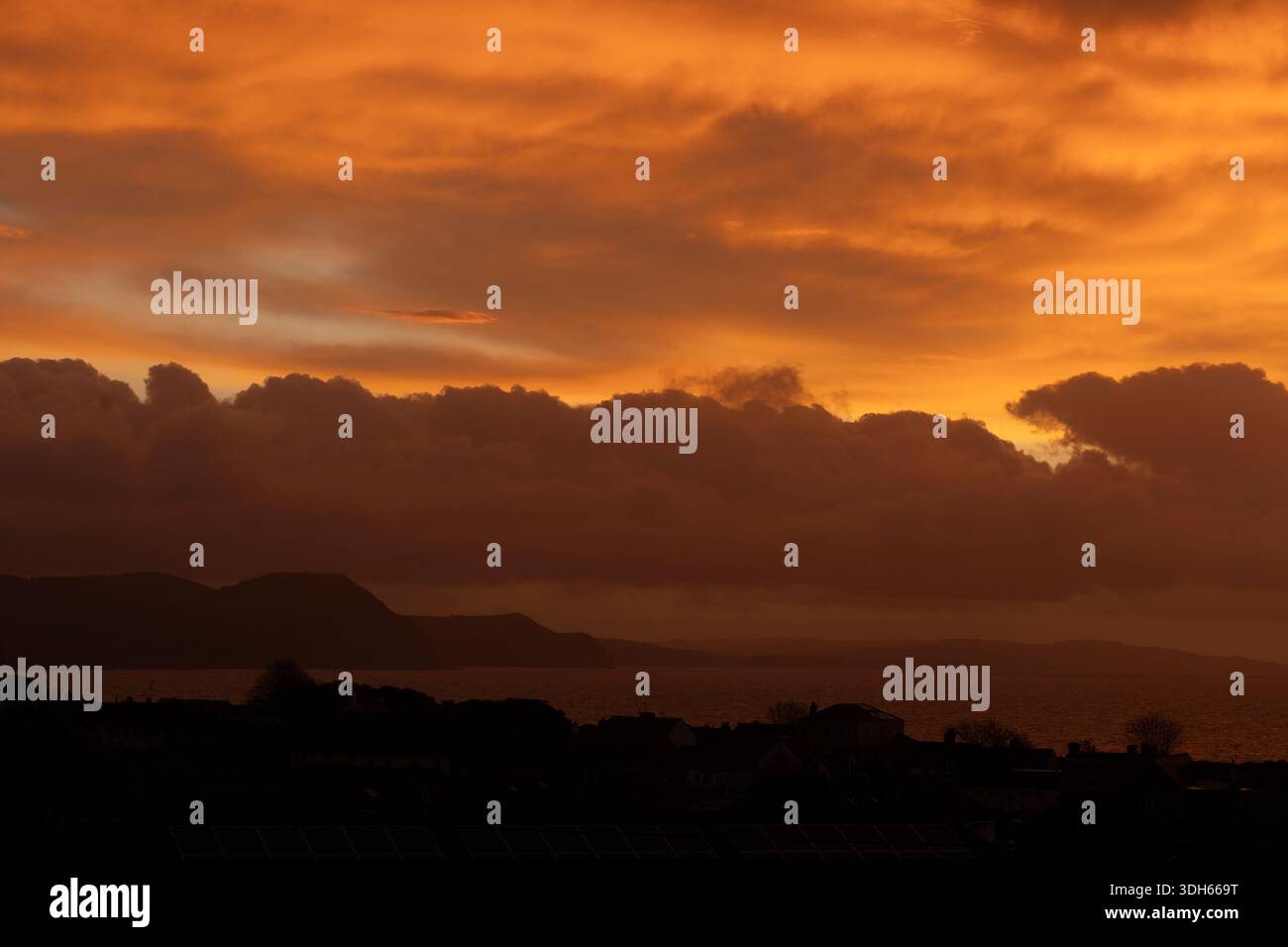Blick in Richtung Charmouth und Golden Cap von Lyme Regis, Dorset, Großbritannien. Sonnenaufgang Stockfoto