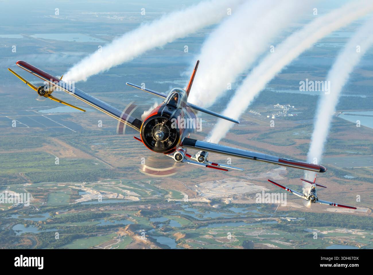 Die nordamerikanischen T-28C Trojan N745W, T-6G Texan N5451E, AT-6D Texan N7572, SNJ-5 Texan N5199V mit dem Namen Gotcha und AT-16 Harvard IIB N8994 sind eine Reihe historischer einmotoriger zweisitziger Trainingsflugzeuge mit Radialkolben. Auf der Sun N Fun Aerospace Expo 2025, Florida, führten diese Flugzeuge Formationsflüge mit Rauchanzeigen durch, wobei sie Kunstflugmanöver, Pilotenfertigkeiten, Flugpräzision und historische Bedeutung in den Pilotenausbildungsprogrammen der US Navy, der US Air Force und der South African Air Force hervorhoben. Stockfoto