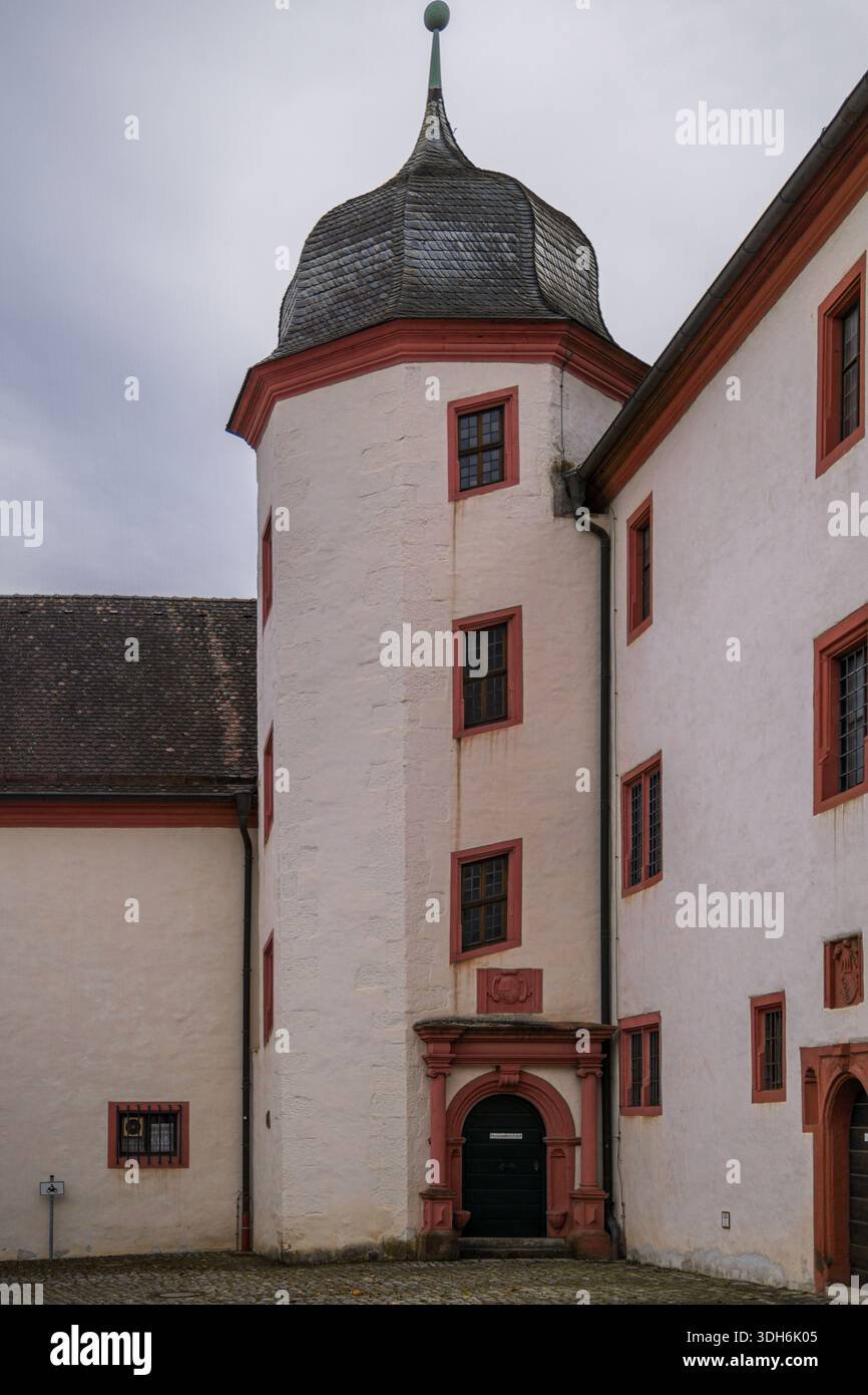 Runder mittelalterlicher Turm im Innenhof der Burg Marienburg mit historischen Putzmauern und einem Steinportal. Stockfoto