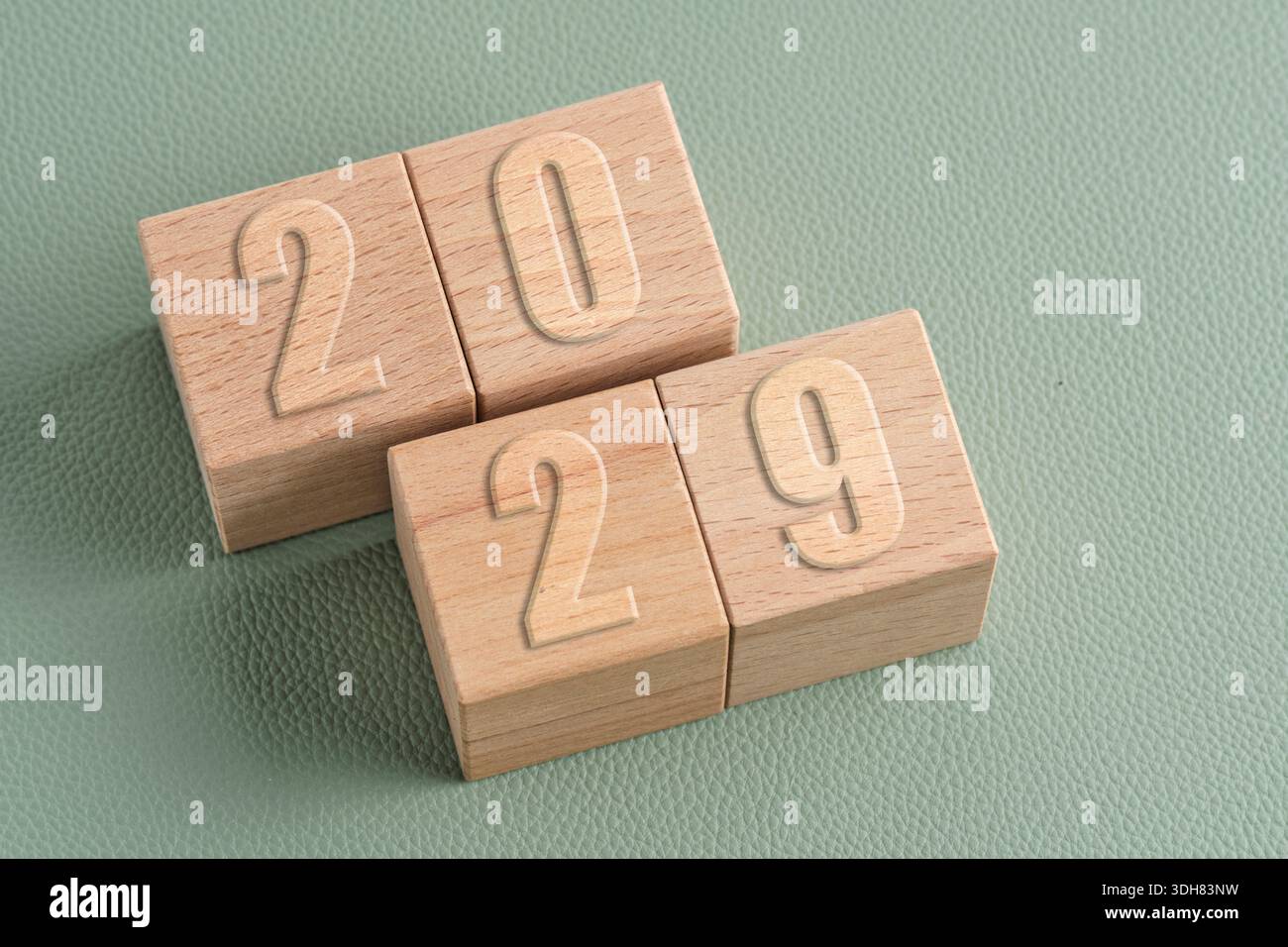Holzwürfel mit den Zahlen 2029 auf grünem Hintergrund. Konzept der Zukunftsplanung und langfristige Ziele Stockfoto