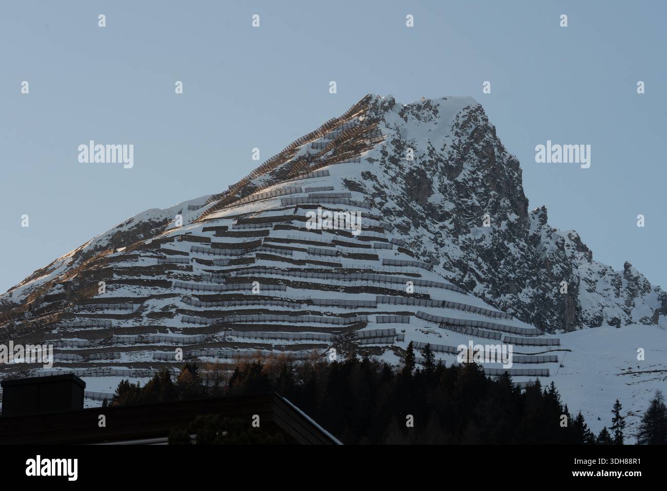 Alpine Winterlandschaft mit ausgedehnten Schneeschranken an einem steilen Berghang Stockfoto