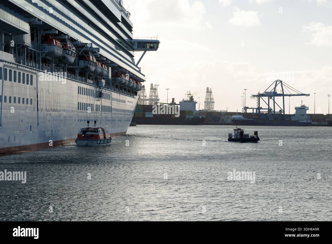 Ausstieg einer kleinen Anzahl von Passagieren von einem riesigen Kreuzfahrtschiff im Hafen von Las Palmas, Gran Canaria, Spanien. Stockfoto