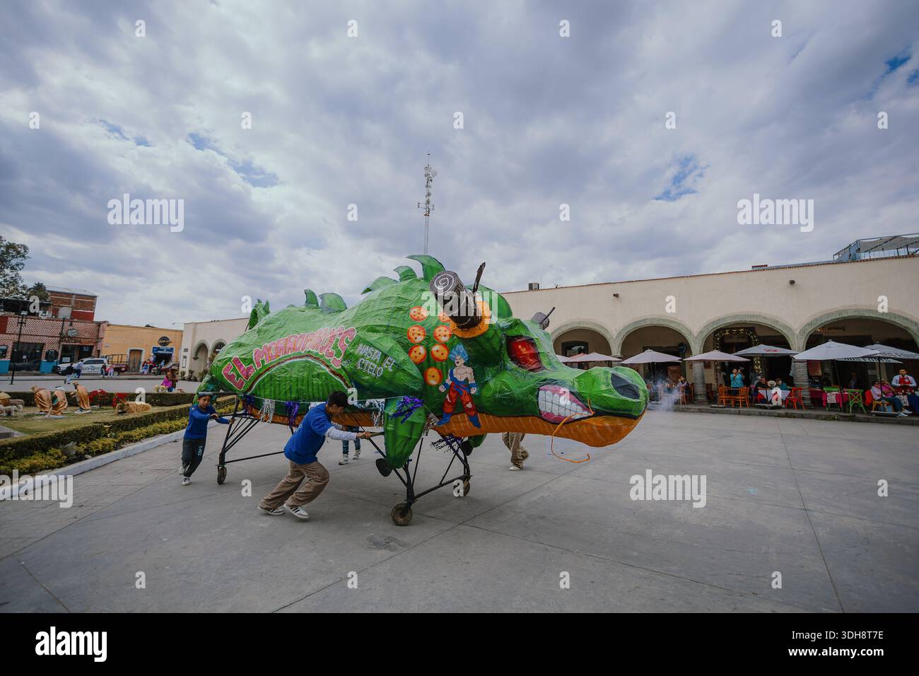 Riesige mâché Skulptur aus grünem Papier in Form eines Drachen mit Anime-Charakteren, die während eines Festivals durch eine Straße bewegt werden. Stockfoto