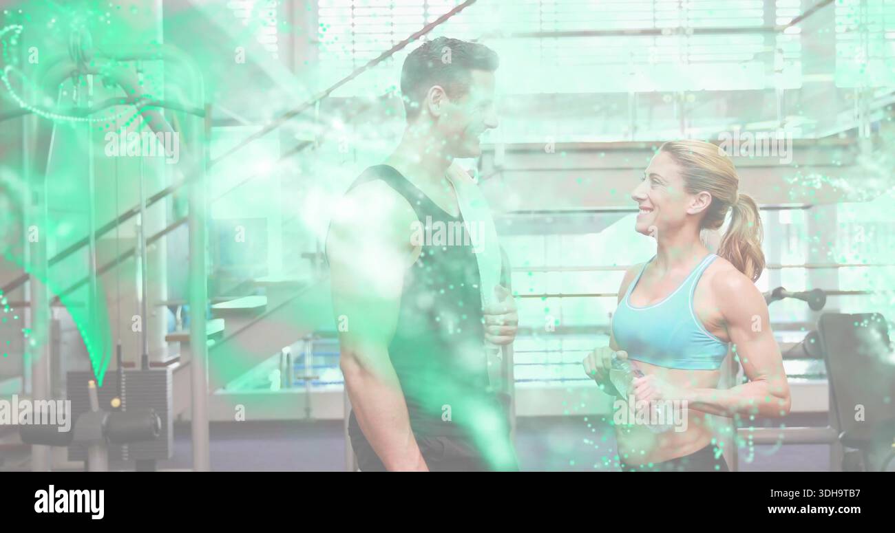 Lächelnder muskulöser Mann mit Handtuch und athletische Frau mit Hanteln in Sportswear Stockfoto