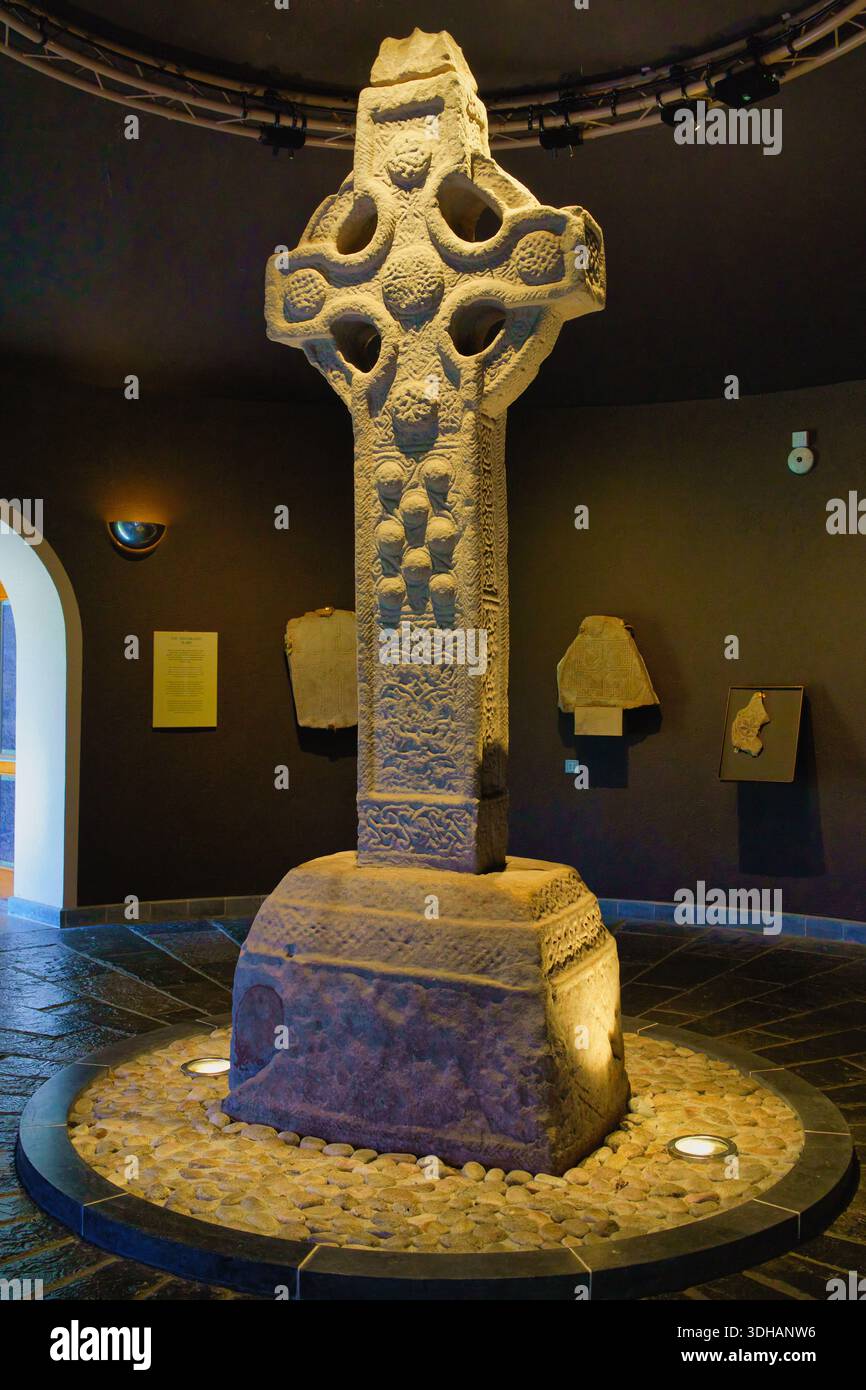 Ein detailliertes Bild eines großen keltischen Kreuzes aus Stein, das komplizierte Schnitzereien in einem Museum in Irland zeigt. Irland, 8. August 2025 Stockfoto