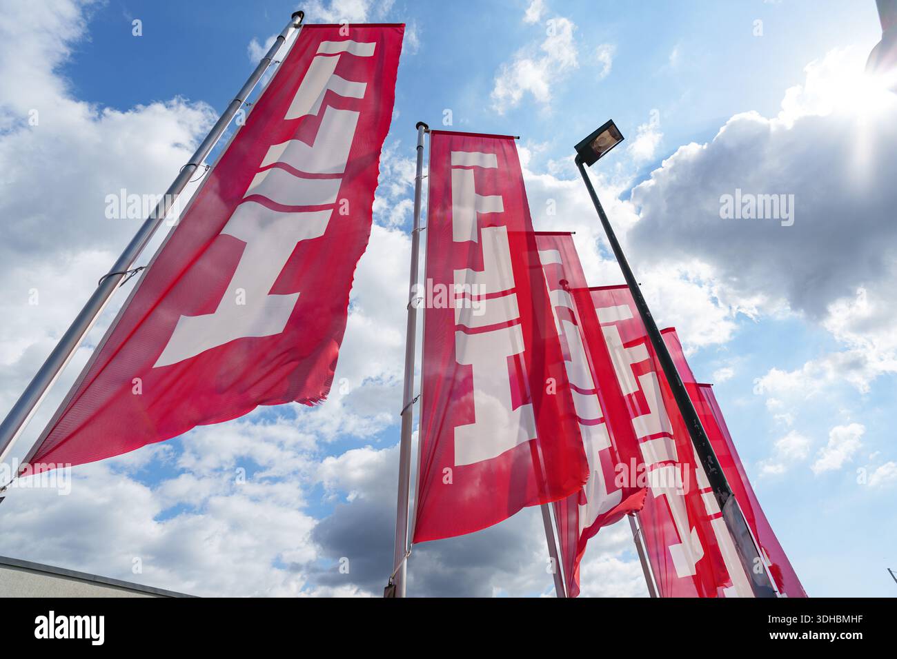 Rote Hilti-Flaggen vor einem Firmenbüro, die das Branding für industrielle Elektrowerkzeuge zeigen Stockfoto