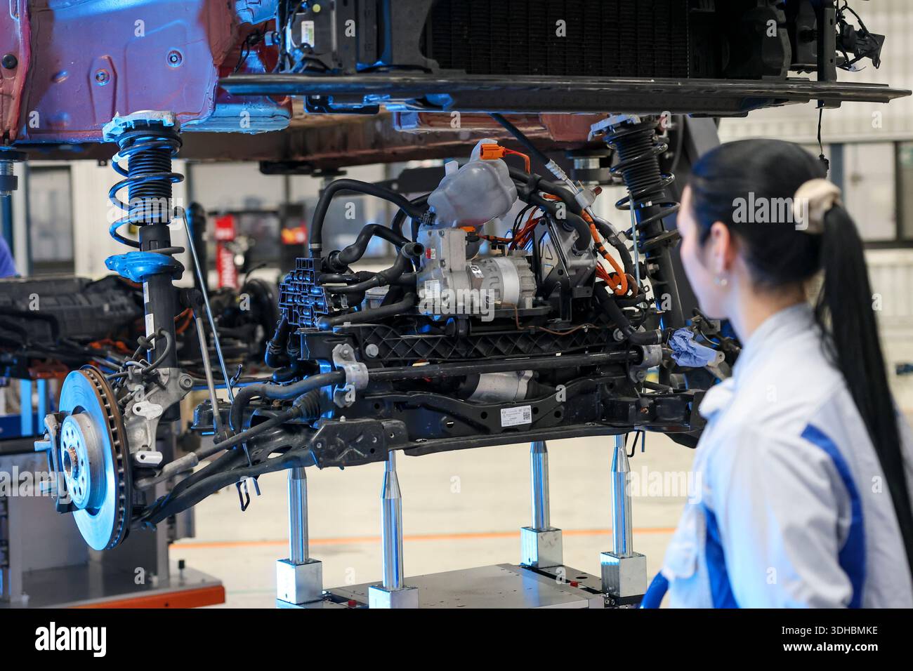 Zwickau, Deutschland. Januar 2026. Bei der Präsentation der Recyclingstrategie im VW-Werk betrachtet ein VW-Mitarbeiter die Vorderachse von einem demontierten VW ID.3. Ab 2030 plant der Automobilhersteller Volkswagen, am Standort Zwickau jährlich bis zu 15.000 Fahrzeuge zu demontieren und zu überholen. Dazu wird Volkswagen Berichten zufolge bis zu 90 Millionen Euro investieren und 1.000 Arbeitsplätze sichern. Das Land Sachsen finanziert das Projekt mit rund 10,8 Millionen Euro. Quelle: Jan Woitas/dpa/Alamy Live News Stockfoto