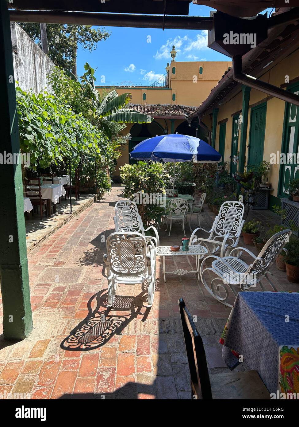 Stühle und Tische stehen in einem schattigen Innenhof in Trinidad, Kuba Stockfoto