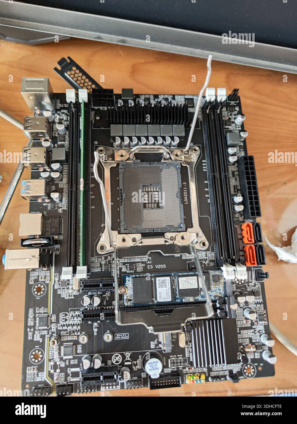 Draufsicht einer Computerplatine mit CPU-Sockel und Komponenten auf Holzoberfläche Stockfoto