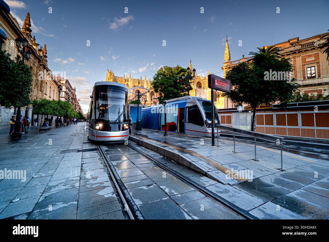 Straßenbahnen halten in Sevilla vor der Kathedrale von Sevilla, Leben auf den Straßen Spaniens. Stockfoto