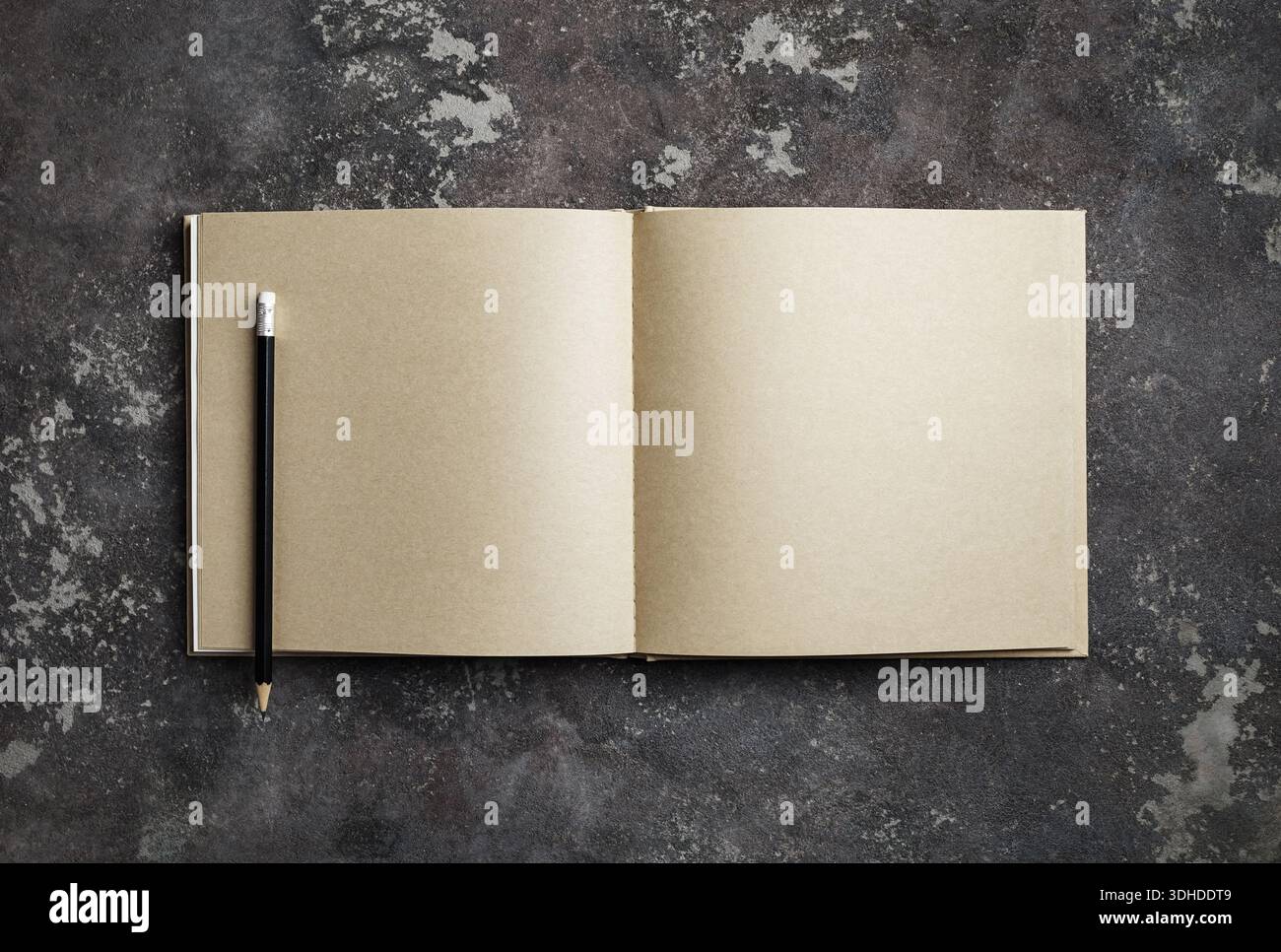 Leeres Kraftskizzenbuch und Bleistift auf Betonoberfläche. Vorlage zum Platzieren des Designs. Flache Lagen. Stockfoto