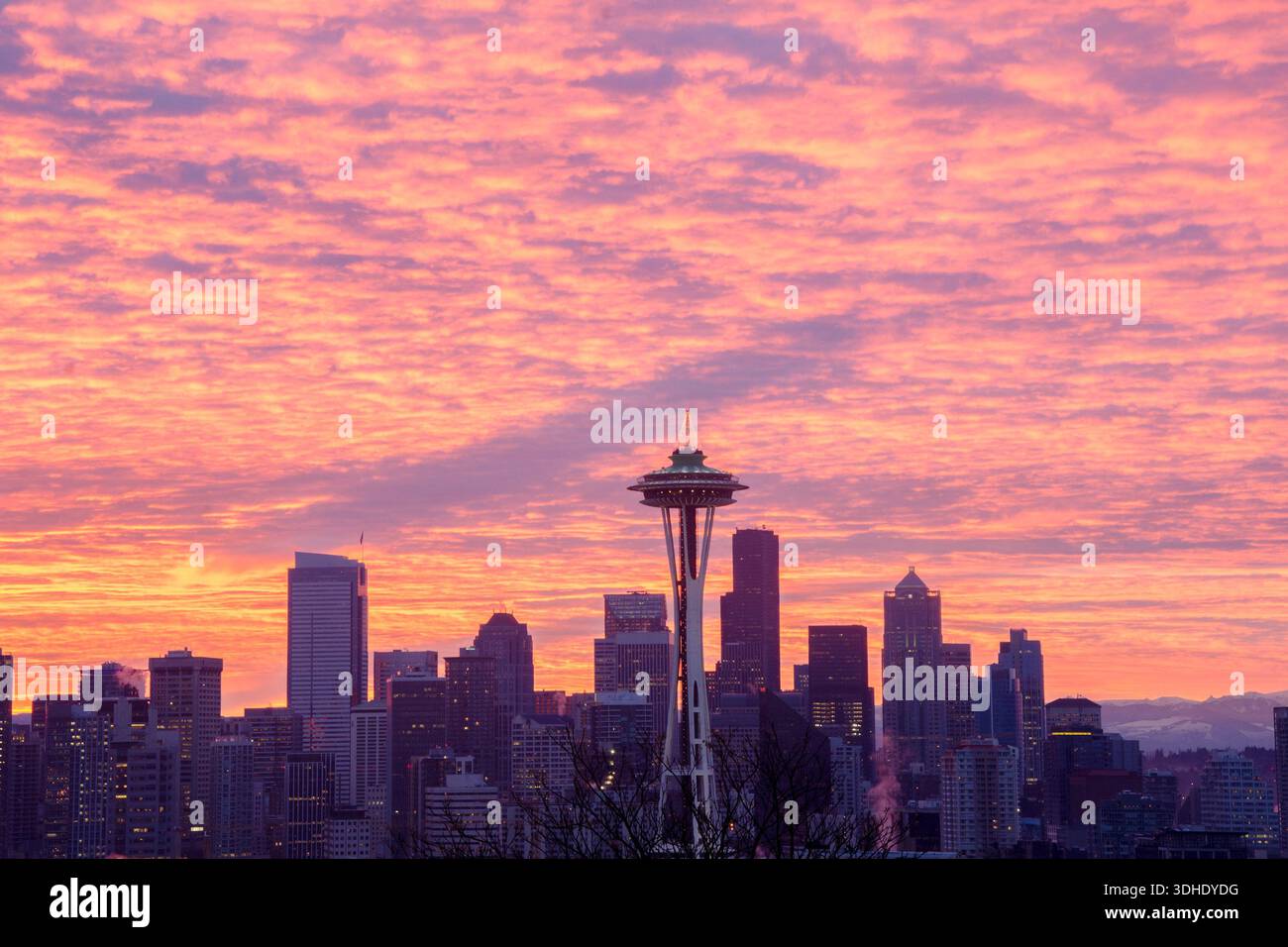 Ein seltener Blick auf den Schatten der Erde während eines farbenfrohen Wintersonnenaufgangs in Seattle. Der niedrige Winkel der aufgehenden Sonne, der perfekt hinter der Stadt ausgerichtet ist Stockfoto