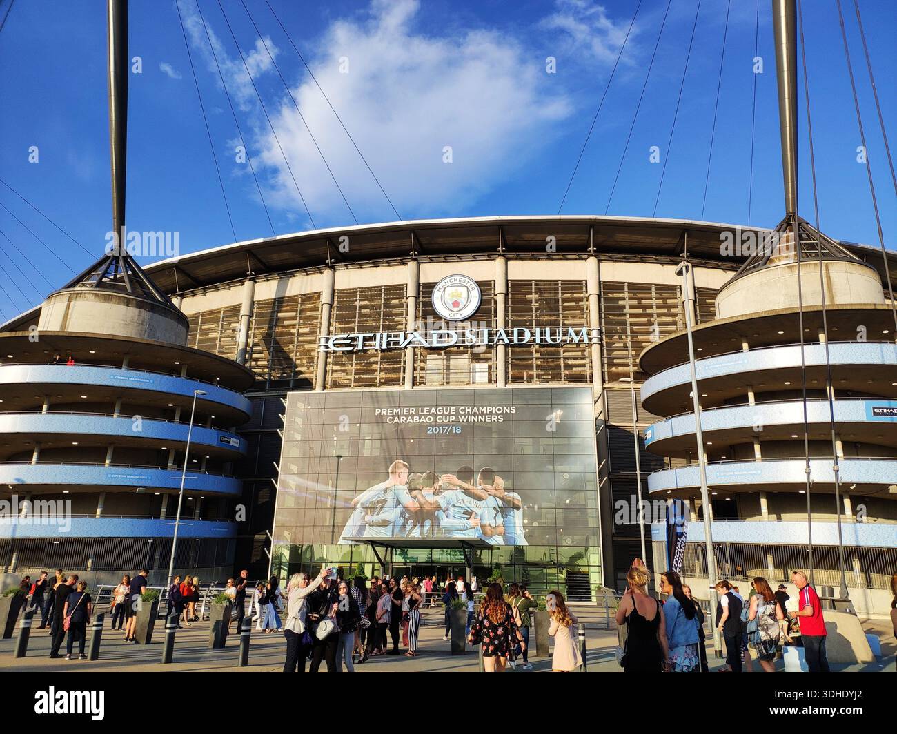 Außenansicht des Etihad Stadions mit Fans, die sich an einem sonnigen Tag draußen versammeln Stockfoto