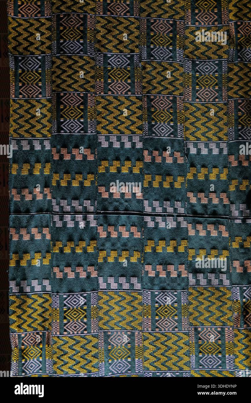 Vollformatansicht von gemusterten Stoffen mit sich wiederholenden Zick-Zack- und Diamantmotiven in Grün, Senf und Hellrosa, sichtbare Nähte Stockfoto