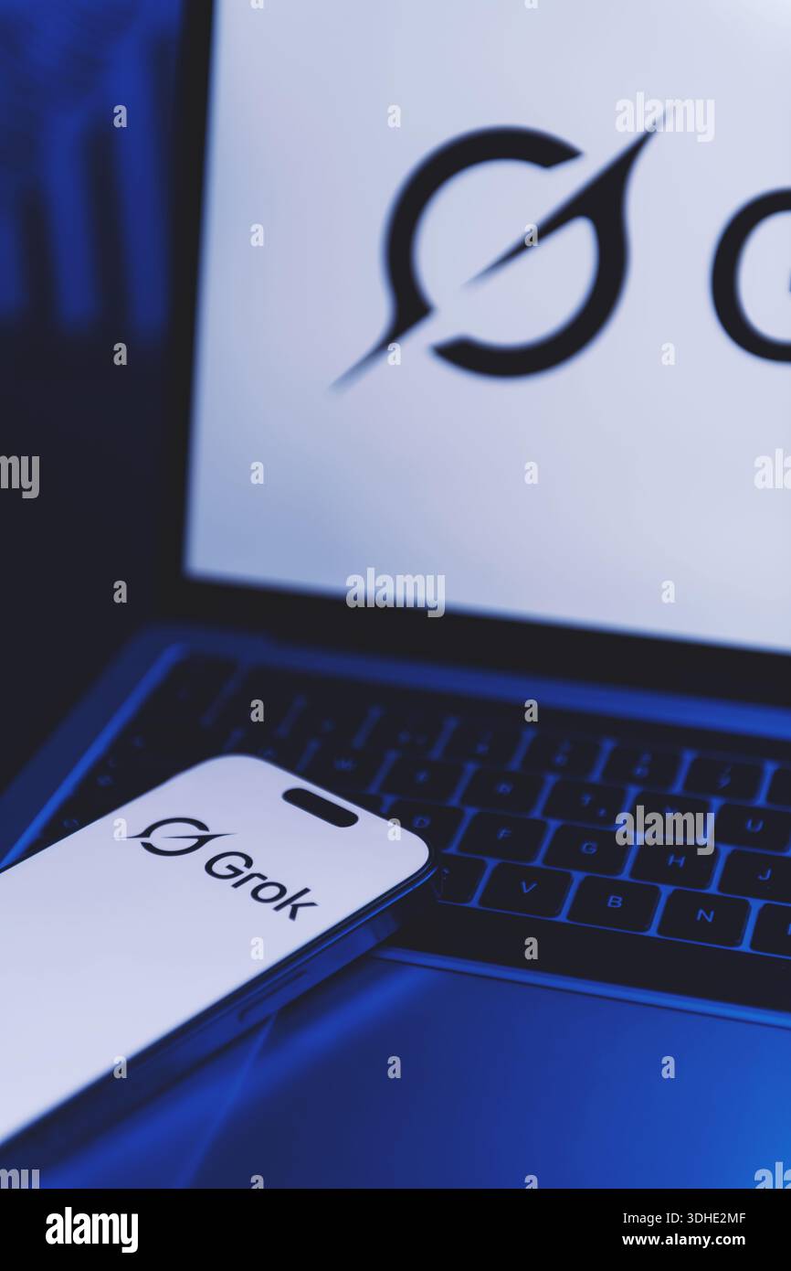 Izmir, Türkei - 21. Januar 2026: Foto eines Laptops mit Grok AI Logo auf weißem Hintergrund, modernes Smartphone auf der Tastatur, das auch Gro zeigt Stockfoto