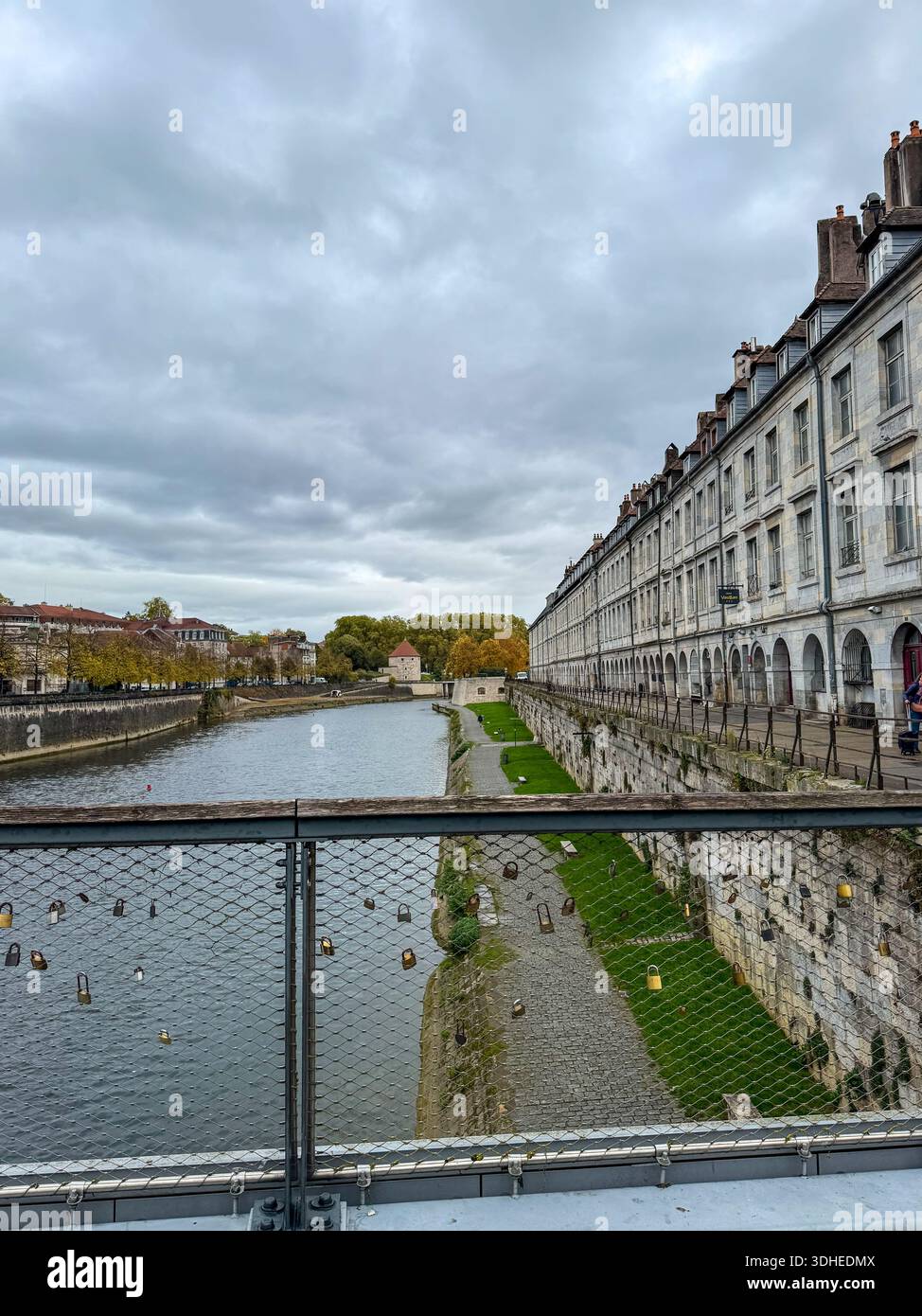 Blick über den Doubs Fluss in Besanco, Frankreich, von einer Fußgängerbrücke mit Love-Vorhängeschlössern entlang des Quai Vauban. Stockfoto