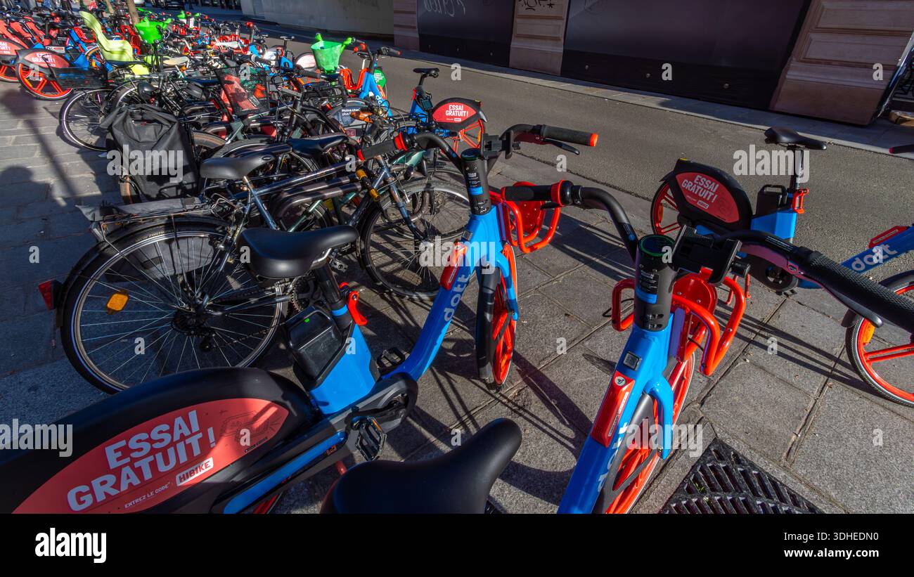 Viele Selbstbedienungsfahrräder, die zu verschiedenen Anlegefahrrädern gehören, und gemeinsame Mobilitätsdienste parken auf einer Straße in Paris, Frankreich Stockfoto