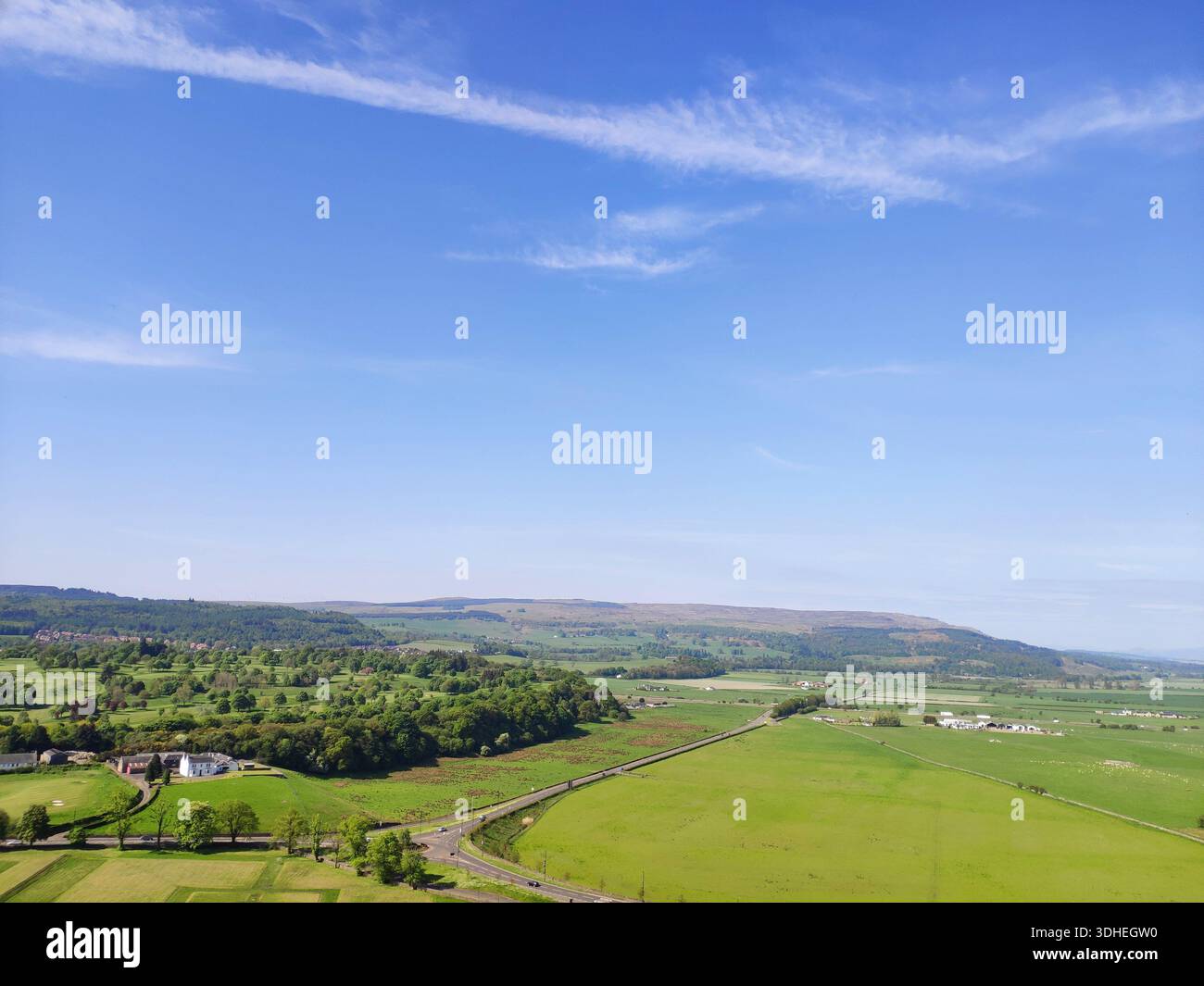 Vogelperspektive auf die rollende grüne Landschaft unter dem blauen Himmel Stockfoto