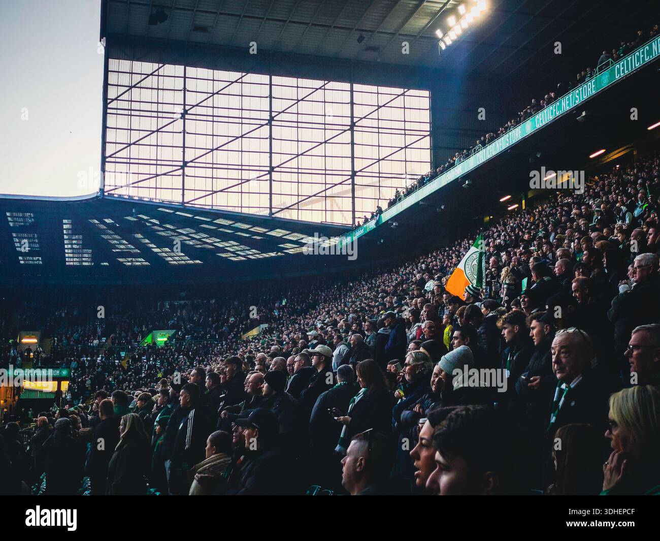 Die Zuschauer füllen die Tribüne im Celtic Park Stadion während eines Fußballspiels, während die Fans stehen und das Geschehen in Glasgow, Schottland, beobachten. Stockfoto
