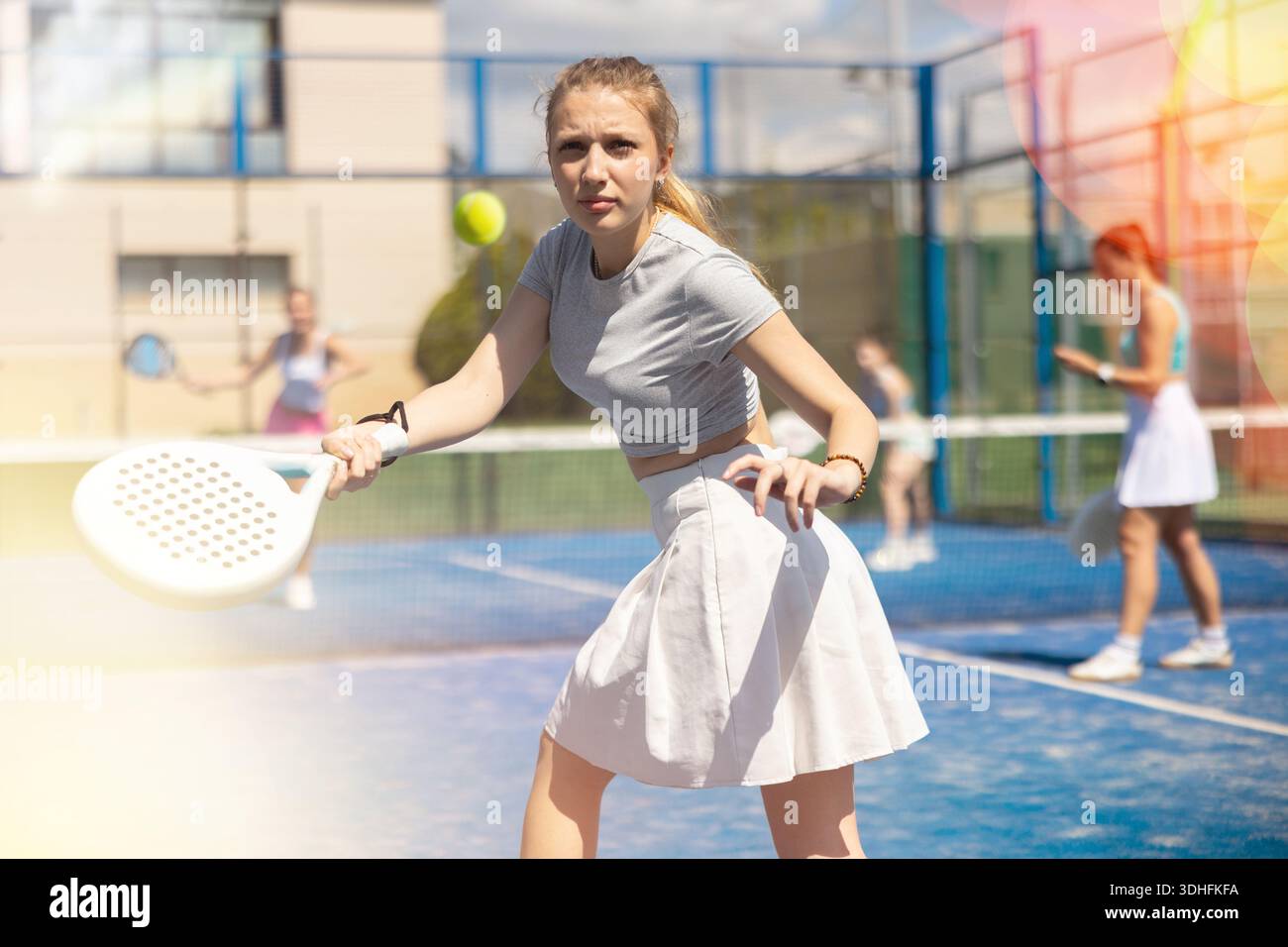 Sportliche Frau, die Schläger beim Paddle-Tennis-Wochenende in Parks spielt Stockfoto