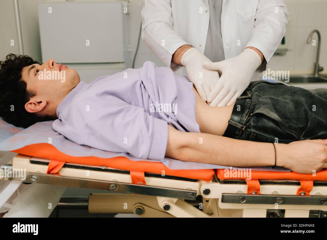 Der Urologe untersucht auf dem Rücken liegende männliche Nieren auf Schmerzgröße oder Entzündung Stockfoto
